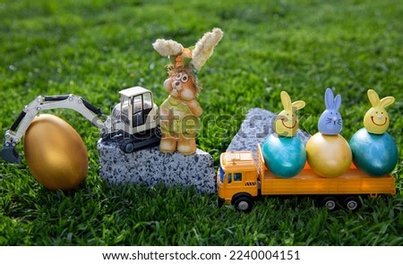 models of a toy excavator and a yellow dump truck with bright colorful  eggs. Easter spring holiday concept for congratulations from construction companies. easter card