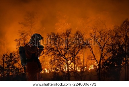 Firefighters battle a wildfire because climate change and global warming is a driver of global wildfire trends. Royalty-Free Stock Photo #2240006791