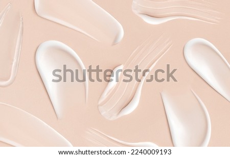 pattern cosmetic smears of creamy texture on a beige background	