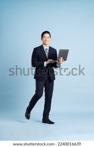 portrait of asian businessman wearing suit on blue background Royalty-Free Stock Photo #2240016639