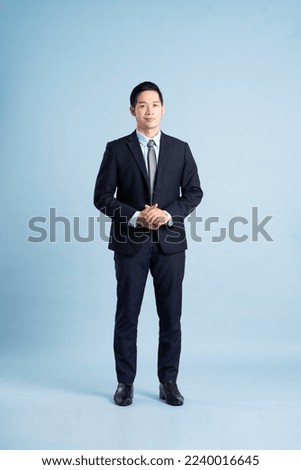 portrait of asian businessman wearing suit on blue background Royalty-Free Stock Photo #2240016645