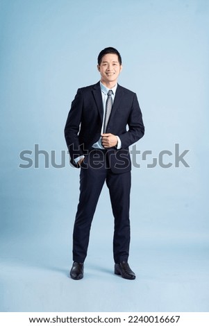 portrait of asian businessman wearing suit on blue background Royalty-Free Stock Photo #2240016667