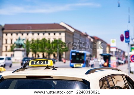 A close-up shot of a taxi sign on the car in the streets of Munich, Germany