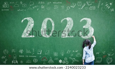 2023 Happy new year school class academic calendar with student kid's hand drawing greeting on teacher's green chalkboard for educational celebration, back to school, STEM education classroom schedule Royalty-Free Stock Photo #2240023233