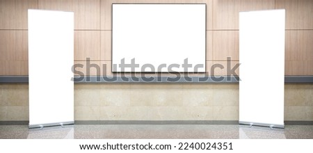Blank roll up stand banner. Blank mockup for presentation isolated on wall background in hospital, hotel, airport. A large, blank billboard is mounted on the wall between the corridors. Royalty-Free Stock Photo #2240024351