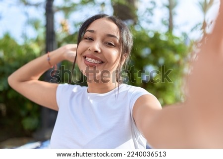 Young arab woman smiling confident making selfie by camera at street
