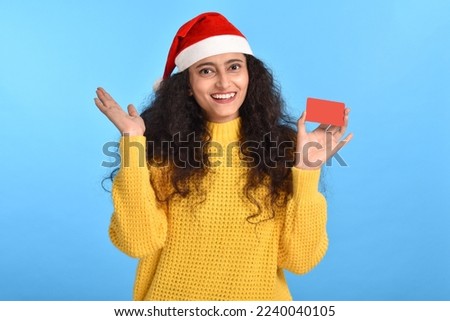 Happy Young woman wearing santa cap and holding credit card stock photo