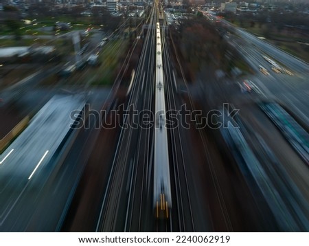 An aerial view of a high-speed train in motion on tracks in the city