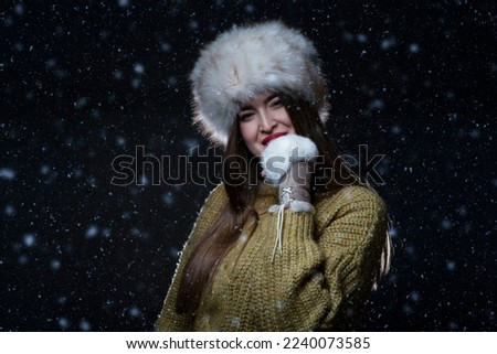 The girl enjoys the night in the first snow of winter.Studio concept.
