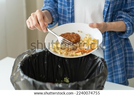 Compost from leftover food, refuse asian young housekeeper woman, girl hand using fork scraping waste from dish, throwing away putting into garbage, trash or bin.
Environmentally responsible, ecology. Royalty-Free Stock Photo #2240074755
