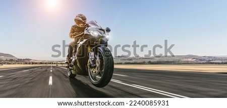 motorbike on the road riding. having fun driving the empty road on a motorcycle tour journey. copyspace for your individual text. Royalty-Free Stock Photo #2240085931
