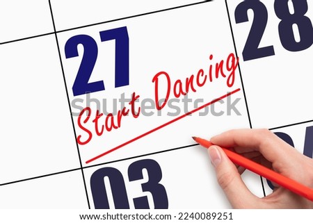 27th day of the month. Hand writing text START DANCING and drawing a line on calendar date. Save the date. Deadline. Business concept Day of the year concept.