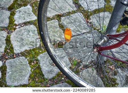 A close-up of a bicycle wheel on the paved road