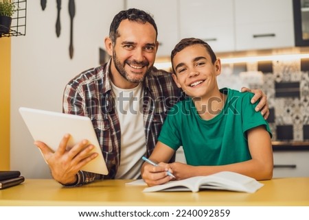 Father is helping his son with learning. They are doing homework together. Royalty-Free Stock Photo #2240092859