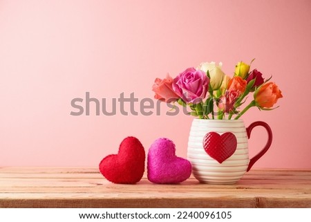 Happy Valentine's day concept with rose flowers and heart shapes on wooden table over pink background