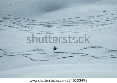 snow covered ground with lines of the off-piste
