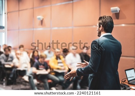 Speaker at Business Conference with Public Presentations. Audience at the conference hall. Entrepreneurship club. Rear view. Horisontal composition. Background blur. Royalty-Free Stock Photo #2240121161