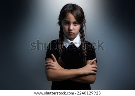 a girl in a Wednesday Addams costume style Royalty-Free Stock Photo #2240129923
