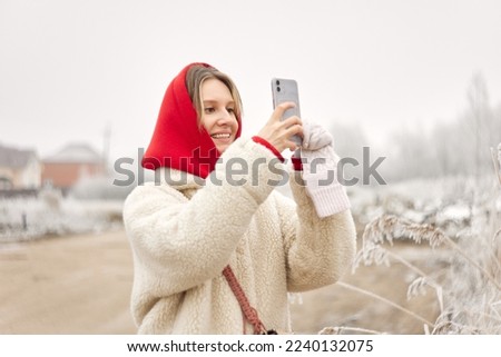 Young woman taking picture outside in winter