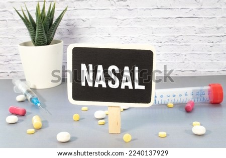 Medicine concept. On the table is a stethoscope, a pen, blue crumpled pieces of paper and a sign with the inscription - Runny Nose