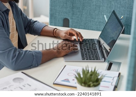Close up of unrecognizable black man typing at laptop keyboard while using laptop at workplace, copy space Royalty-Free Stock Photo #2240141891