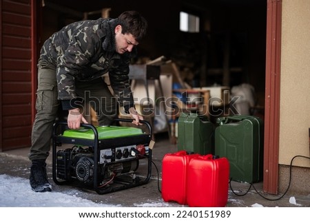 Man wear in military jacket with gasoline portable mobile backup standby generator. Royalty-Free Stock Photo #2240151989