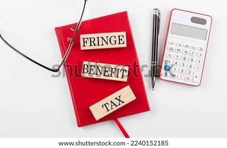 FRINGE BENEFIT TAX text on a wooden block on red notebook Royalty-Free Stock Photo #2240152185