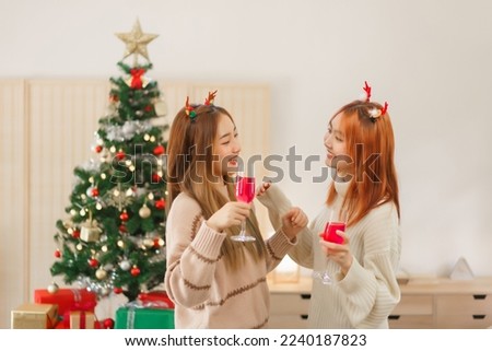 Christmas festive concept, Two women are drinking champagne and dancing near christmas tree.