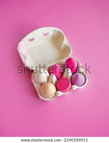 Beauty sponges for make-up in an egg tray on a violet background