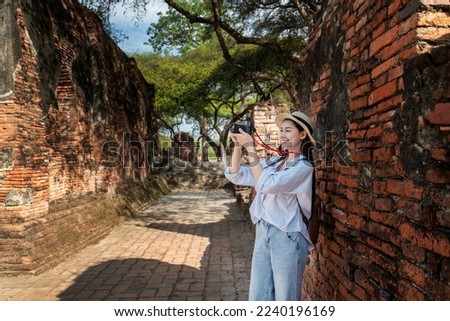 Portrait pretty young woman pose having fun and happy in famous the ancient palace in Ayutthaya with camera travel with take photo is travel holiday relaxed concept. 