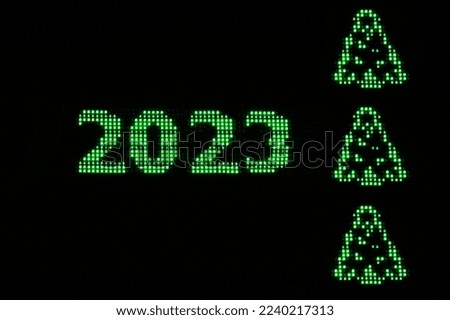 Bright green numbers 2023 and spruce on a black background