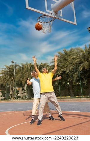 Two seniors on the basketball field playing basket.