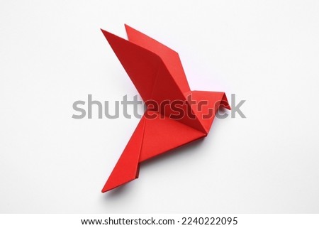 Beautiful red origami bird on white background, top view Royalty-Free Stock Photo #2240222095