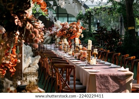 Wedding dinner table reception at sunset outside, wooden chair in wedding Royalty-Free Stock Photo #2240229411