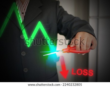 A business investor use scissors to cut loss in order to prevent more losses or damage the business. Accounting, financial, and business concept