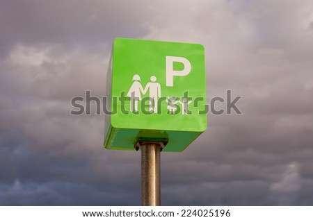 Reserved for families. Car park sign pole against cloudy sky 