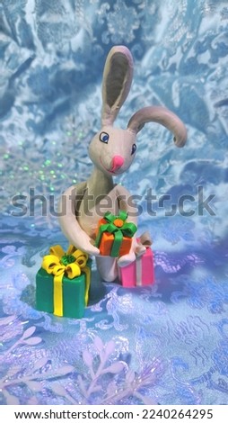 new year bunny 2023 with gifts miniature for cards of christmas greetings or fabulous background for desktop wallpaper with new year theme white rabbit made of plasticine toy 