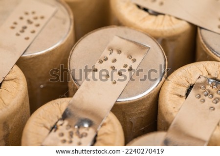 Extreme Closeup of Bundle of Soldered Ni-Mh Rechargeable Batteries  Placed Together Over Beige.Horizontal Image Royalty-Free Stock Photo #2240270419