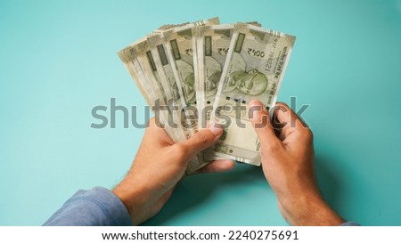 Unrecognizable hand counting five hundred Indian rupees, Close up of hand holding cash. Royalty-Free Stock Photo #2240275691
