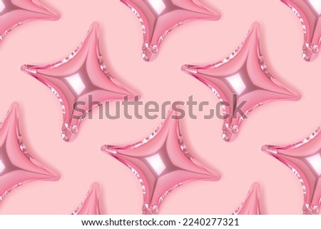 Repetitive pattern made of inflatable star balloons on a pink background. Monochrome concept.