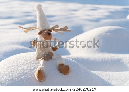 Figure of chrismas deer on snowy field. Concept of funny winter day and christmas spirit.