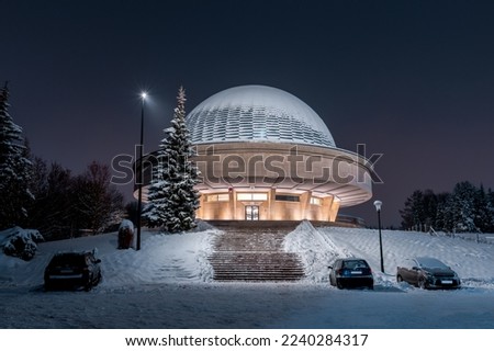 Silesian Planetarium during the blue hour. Beautiful winter scenery. The snow-covered dome of the observatory Royalty-Free Stock Photo #2240284317