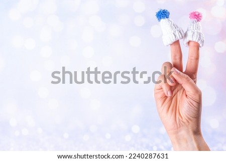 Funny cartoon fingers characters in hats. Fingers with happy faces in winter hats on snowy festive lights background copy space. Christmas vacation, family time celebrating concept, banner format