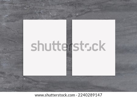 Closeup of two posters styled on an elegant gray marble background.