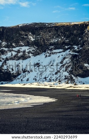 Tourists on picturesque Iceland beach landscape photo. Beautiful nature scenery photography with cliffs on background. Idyllic scene. High quality picture for wallpaper, travel blog, magazine, article