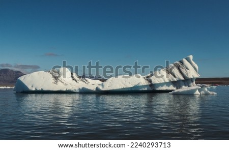Huge glacier in calm northern sea landscape photo. Beautiful nature scenery photography with blue sky on background. Idyllic scene. High quality picture for wallpaper, travel blog, magazine, article