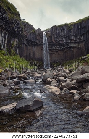 Svartifoss waterfall on rock landscape photo. Beautiful nature scenery photography with cloudy sky on background. Idyllic scene. High quality picture for wallpaper, travel blog, magazine, article