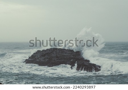 Heavy splashes over old rock landscape photo. Beautiful nature scenery photography with seaside on background. Idyllic scene. High quality picture for wallpaper, travel blog, magazine, article