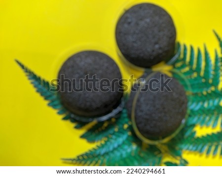 blurred three black buns on a yellow background for the cover