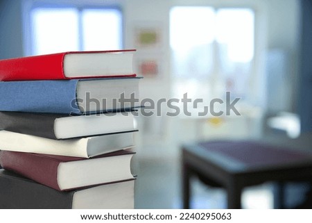 Many stacked hardcover books in office, space for text